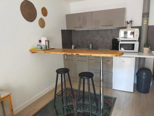 a kitchen with two bar stools and a counter at spéculoos et chicorée in Villeneuve d'Ascq