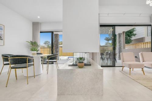 a living room with a table and chairs at Luxurious Lakeside Oasis in Morisset East