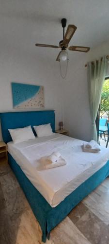 a bedroom with a large bed with a ceiling fan at Angel's Place by the Sea in Diakopto