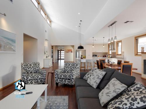 a living room with a couch and a dining room at Luxury Waterfront Holiday Home - Bring the Boat! in Hindmarsh Island