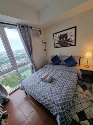 a bedroom with a bed and a large window at Casa REYNA at KASARA Urban Residences in Manila