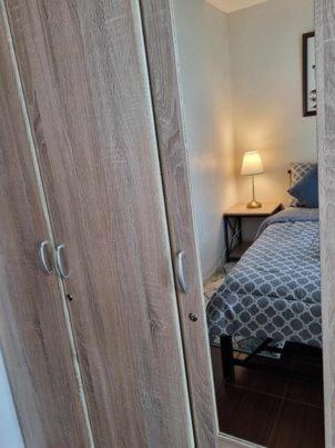 a door to a bedroom with a bed and a lamp at Casa REYNA at KASARA Urban Residences in Manila