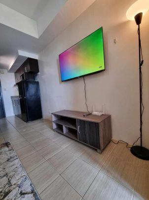 a living room with a flat screen tv on the wall at Casa REYNA at KASARA Urban Residences in Manila