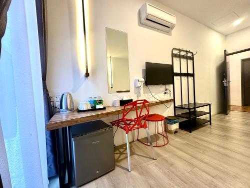 a room with a desk and a red chair at C Y C Heritage Hotel in George Town