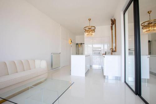 un salon blanc avec un canapé et une table dans l'établissement LUXE SUR LE PORT, à Marseille