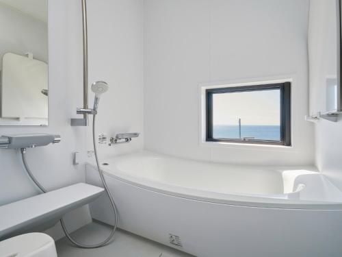 a bathroom with a tub and a sink and a window at Kino-saji - Vacation STAY 89208 in Ibusuki