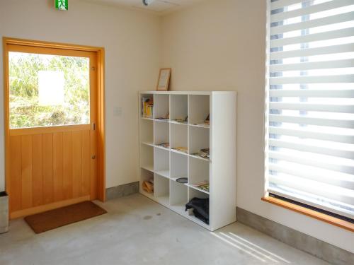 ein weißes Bücherregal in einem Zimmer mit Fenster in der Unterkunft Kino-saji - Vacation STAY 89208 in Ibusuki