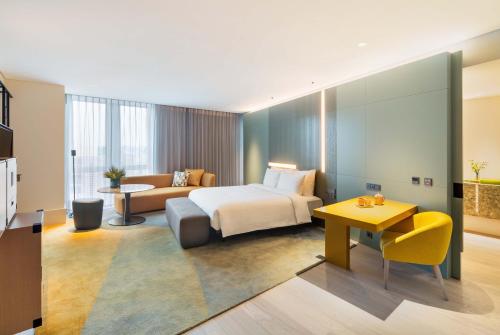 a hotel room with a bed and a couch at Andaz Seoul Gangnam in Seoul