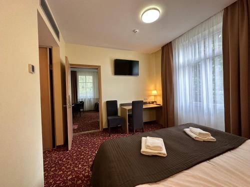 a hotel room with a bed with two towels on it at City Gate in Vilnius