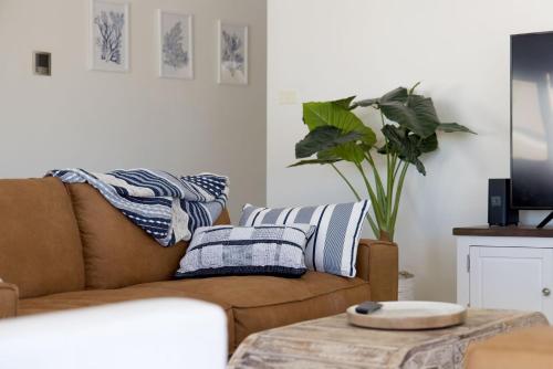 a living room with a couch and a table with pillows at Nelson Bay Apartment with views over the Marina in Nelson Bay