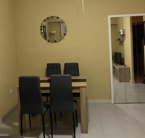 een eettafel met 4 stoelen en een spiegel bij APARTAMENTO LORE PLAYA in Santa Pola