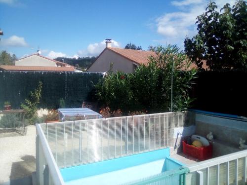 a swimming pool in a backyard with a white fence at Christophe in Crest