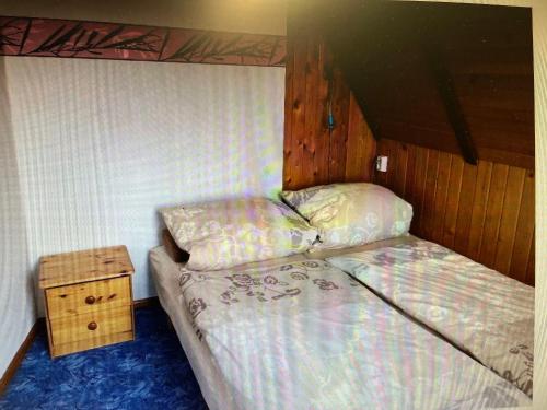 ein kleines Schlafzimmer mit einem Bett und einem Nachttisch in der Unterkunft Ferienhaus Günther Harzgerode/Schielo in Schielo