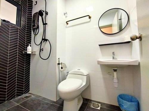 une salle de bain avec toilettes, lavabo et miroir dans l'établissement Urbanite Premier Suite - Horizon Ipoh by Grab A Stay, à Ipoh