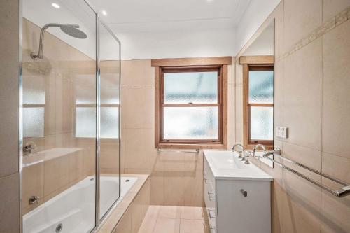 y baño con bañera, lavamanos y ducha. en Maple Cottage Porepunkah en Porepunkah
