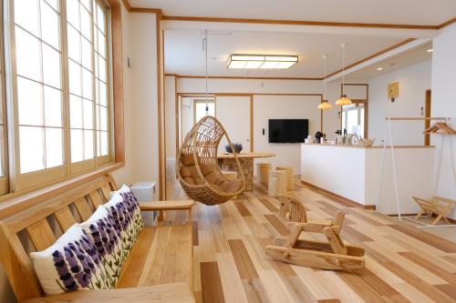 a living room with a couch and a rattan chair at ヴァンテアン舎（vingt et un house） in Biei