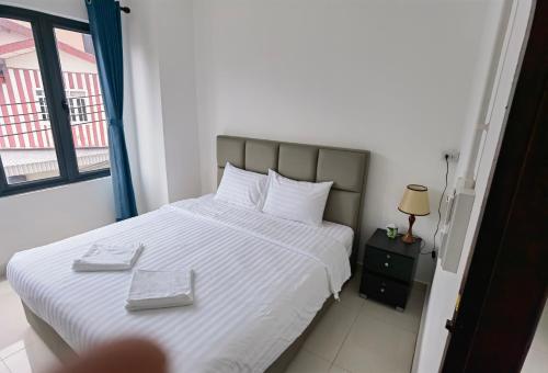 a bedroom with a bed with white sheets and a window at ChanthaSouk Vang Vieng Entire Villa in Vang Vieng