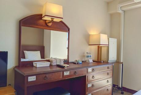 a bedroom with a dresser with a mirror and a bed at City Pension Zem in Tokyo