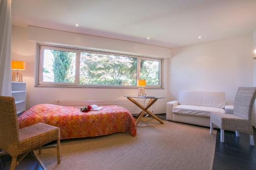 PuraにあるVilla Blu Ortensia - Happy Rentalsのベッドルーム1室(ベッド1台、椅子、窓付)