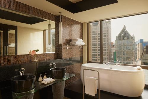 ein Badezimmer mit Badewanne und großem Fenster in der Unterkunft Banyan Tree Bangkok in Bangkok