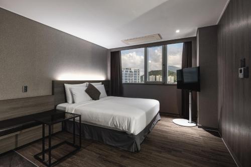 a hotel room with a bed and a television at Kent Hotel Gwangalli by Kensington in Busan