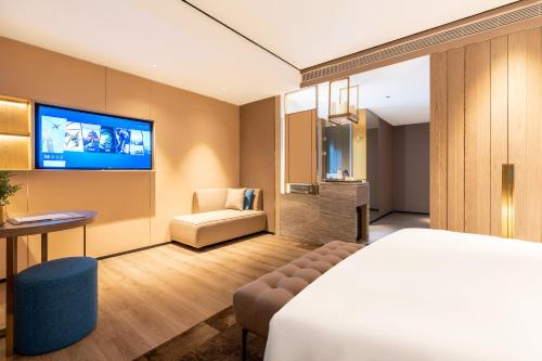 TV a/nebo společenská místnost v ubytování Echarm Plus International Hotel Hangzhou Binjiang XingGuang Avenue Pedestrian Street Branch