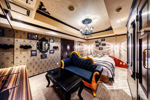 a bedroom with a bed and a blue couch at Hotel Luna Machida -Adult Only in Machida