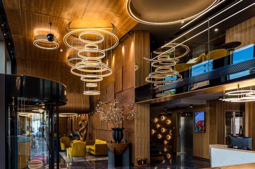 a lobby with a bunch of lights hanging from the ceiling at Hotel Vibre in Cluj-Napoca