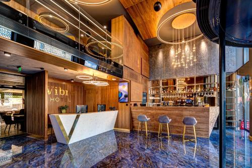 a bar in a restaurant with bar stools at Hotel Vibre in Cluj-Napoca