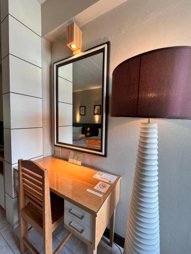 a room with a desk with a mirror and a lamp at Rommai Greenpark in Lampang