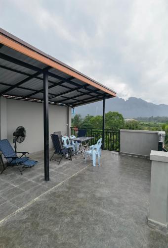 a patio with chairs and tables on a roof at ChanthaSouk Vang Vieng Entire Villa in Vang Vieng