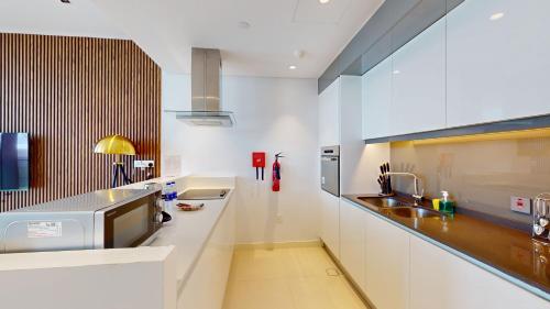 a kitchen with white cabinets and a sink at Primestay - Astonishing 1BR in Bluewaters Island in Dubai