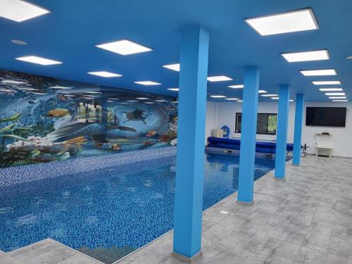 a room with a swimming pool with a mural on the wall at Casa Dana Scorțeni 