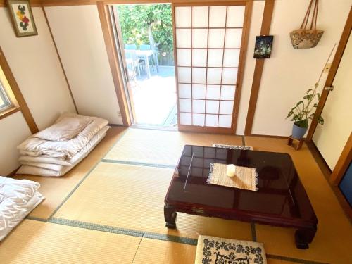 sala de estar con mesa de centro y puerta en 星ノソラ, en Shodoshima
