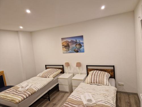 Una habitación con dos camas y un cuadro en la pared. en Capital Apartments, en Düren - Eifel