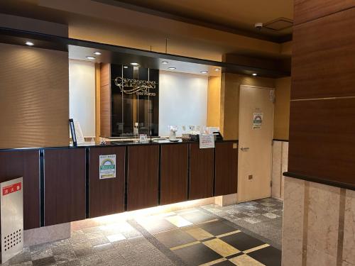 vestíbulo del hotel con mostrador de recepción y espejo en Cypressinn Tokyo, en Tokio