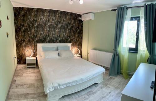 1 dormitorio con cama blanca y pared en Casa Dana Scorțeni, 