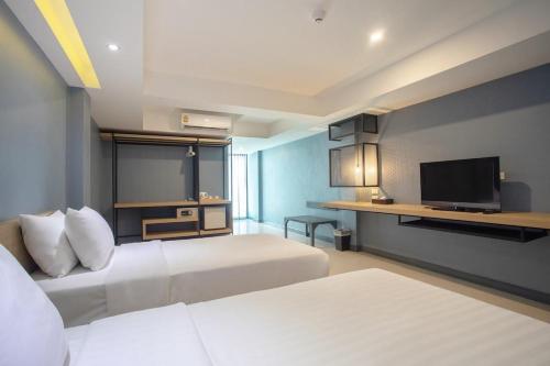 a hotel room with two beds and a flat screen tv at Nora LakeView in Chaweng