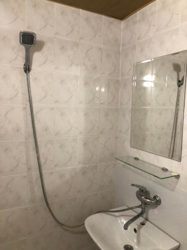 a bathroom with a shower with a sink and a mirror at Hotel Nikea Paradiso in Kutaisi