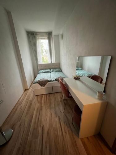 um pequeno quarto com uma cama e uma secretária com um espelho em Apartmán Znojmo 1+1 em Znojmo