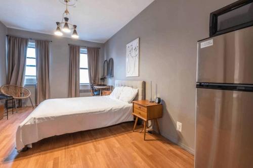 a bedroom with a bed and a refrigerator at Lovely Studio in Heart of NYC (Midtown West) in New York