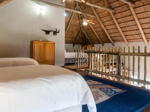 1 dormitorio con cama blanca y alfombra azul en Klipdrift Sands Bush Camp, en Dinokeng Game Reserve