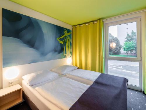 a bedroom with a bed and a window at B&B Hotel Krefeld in Krefeld