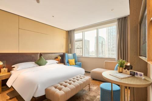 a hotel room with a bed and a table at ECHARM Plus Hotel - Hangzhou Binjiang Starlight Avenue in Hangzhou