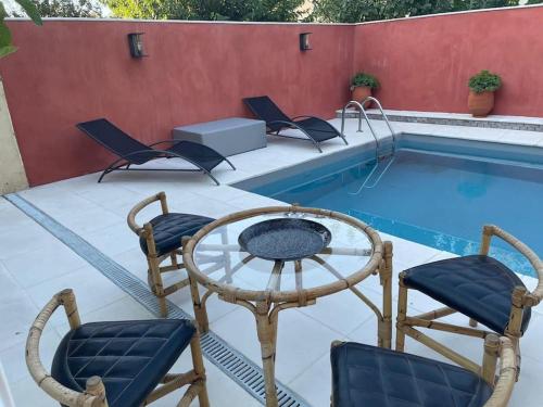 un patio avec des chaises et une piscine dans l'établissement La Cigalière de l Isle, à LʼIsle-sur-la-Sorgue