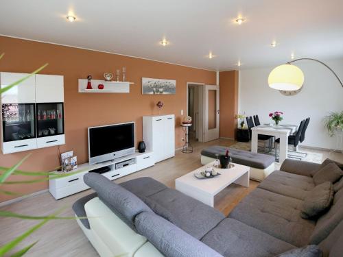 sala de estar con sofá y TV en Ferienwohnungen Haus Angela en Mühlhausen