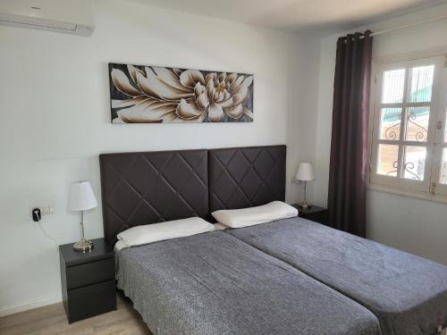 a bedroom with a bed and a painting on the wall at Lago Verde Suite 25 in Puerto del Carmen