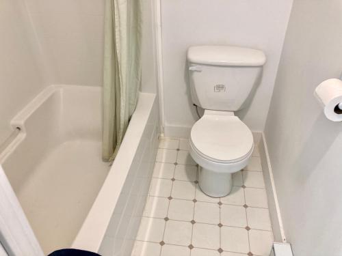 a bathroom with a toilet and a bath tub at Motel 99 in Grand Forks
