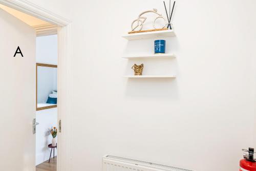 a room with white walls and white shelves at Charming 2-Bedrooms Apartment with a Garden at Abingdon in Oxford