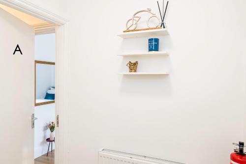 a room with white walls and white shelves at Charming 2-Bedroom Flat with a Garden and Free Parking at Abingdon in Oxford